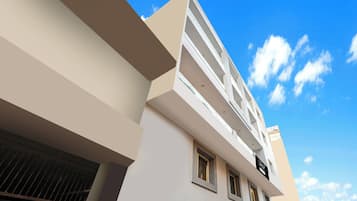 Un edificio de varios pisos con fachada plana, ventanas amplias y cielo despejado.