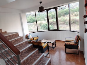 Una habitación con una pared curva, una escalera y vistas a un paisaje montañoso.