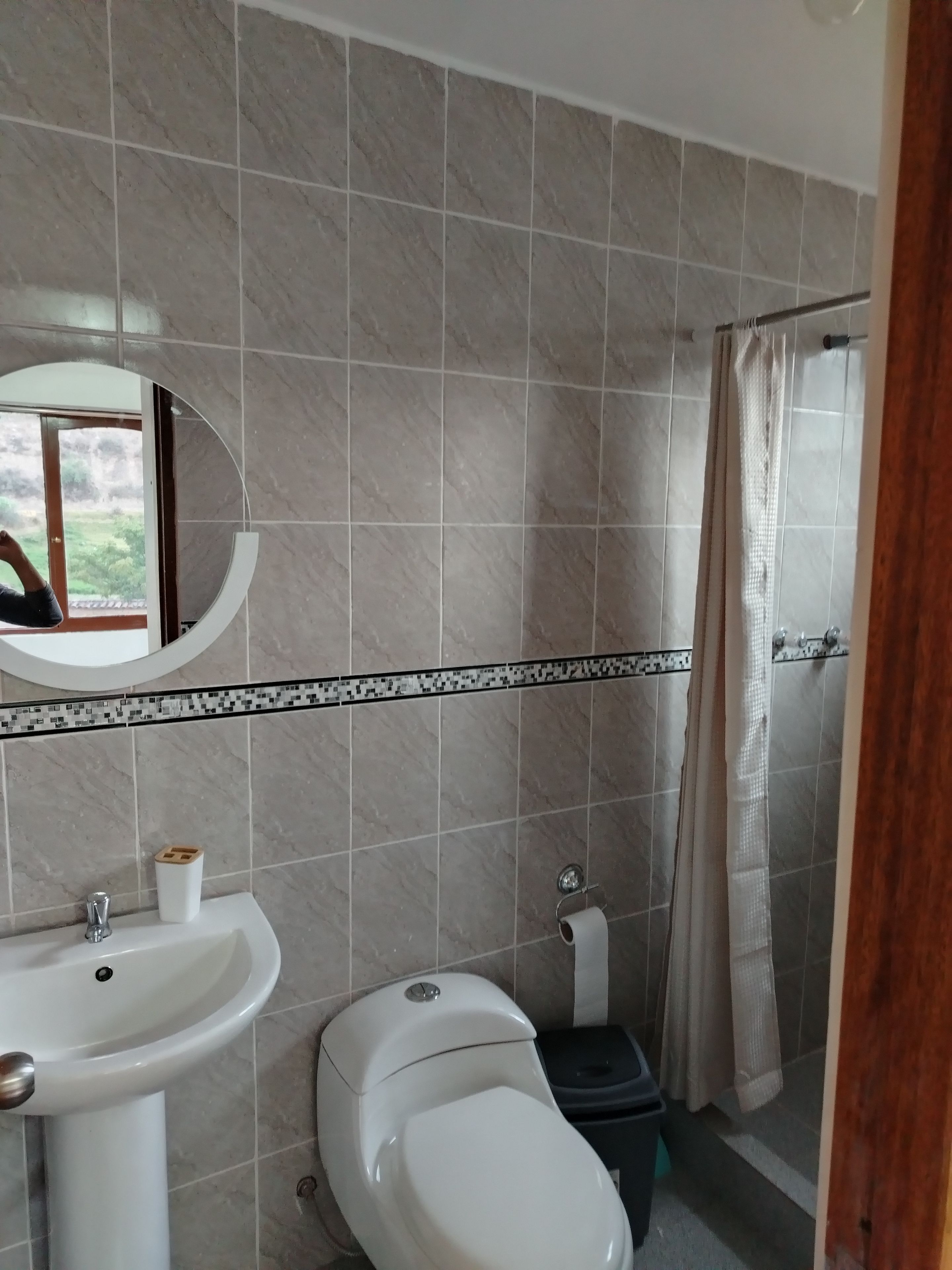 Un baño con lavamanos, inodoro y zona de ducha.