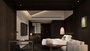 Een moderne hotelkamer met een bed, een bureau, een stoel, een ronde tafel en een televisie.