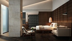Een moderne woonkamer met een bank, fauteuils, een salontafel en een groot raam.