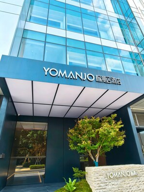 A modern building with a glass facade and a sign reading 'YOMANJO.' - Yomanjo Hotel (Guangzhou)