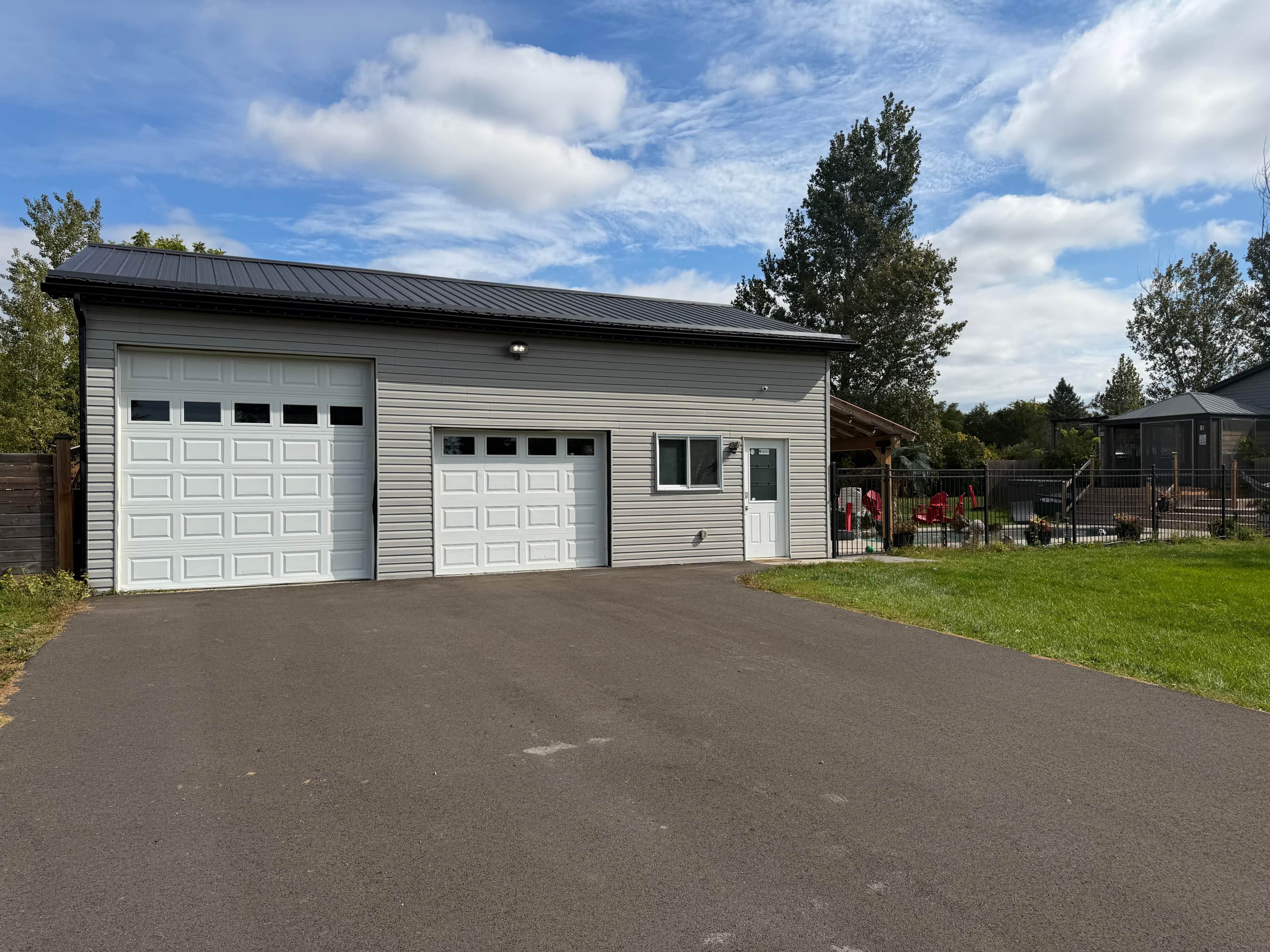 Een gelijkvloers gebouw met garage en overdekte veranda.