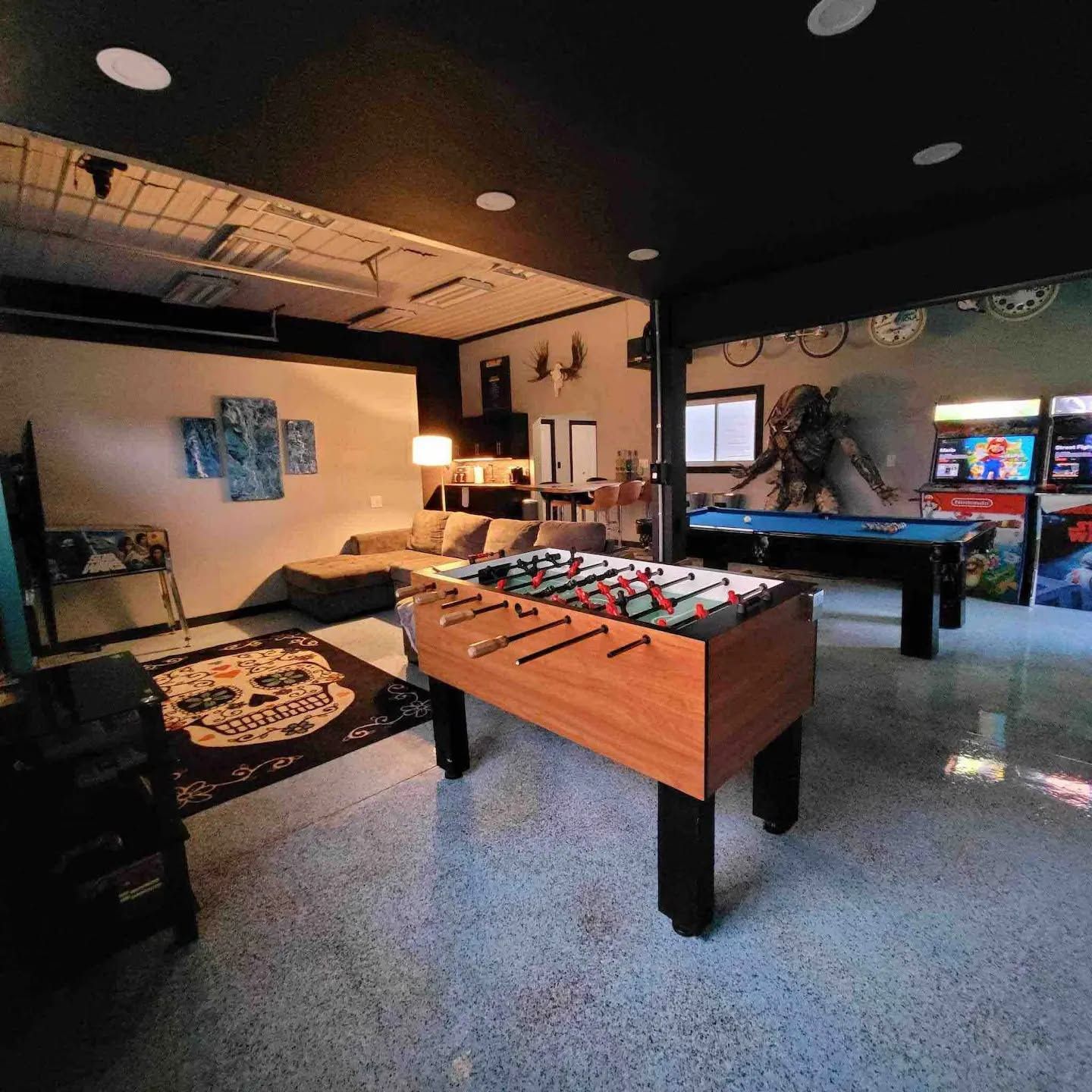 Een kamer met een tafelvoetbaltafel, een pooltafel en een speelhoek met spelautomaten.