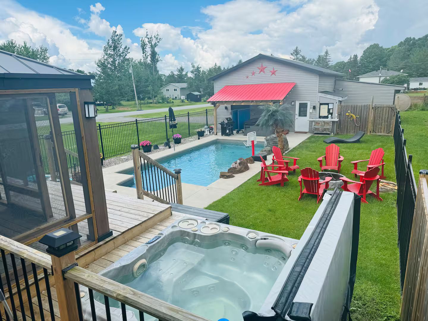 A backyard with a swimming pool, hot tub, and outdoor seating area.