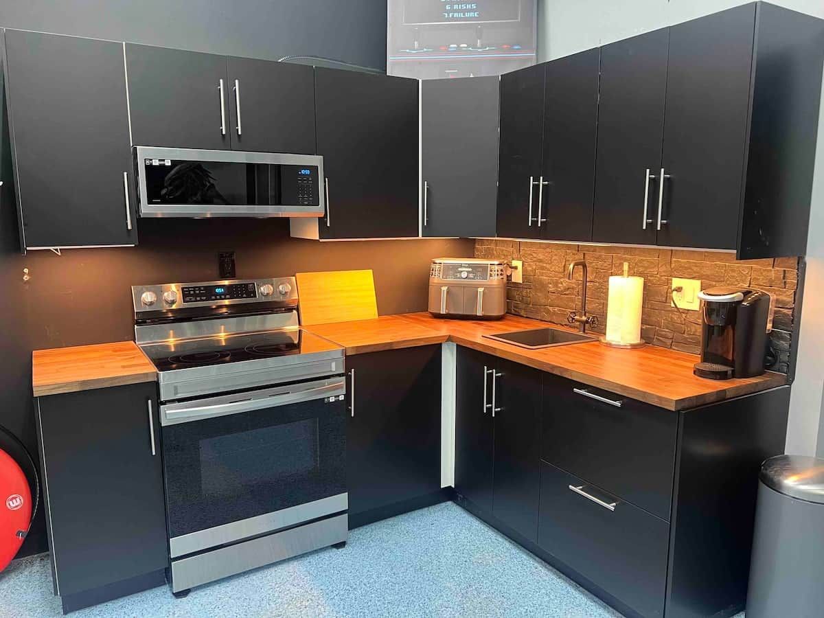 Een kleine keuken met een magnetron, oven, broodrooster en koffiezetapparaat.