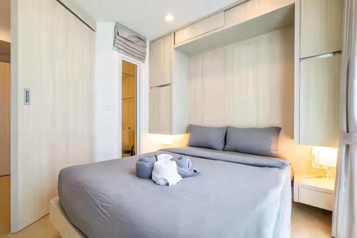 Ein modernes Schlafzimmer mit einem großen Bett, Nachttischen und einem Kleiderschrank.