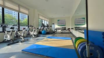 A gym with exercise equipment, mats, and weights.