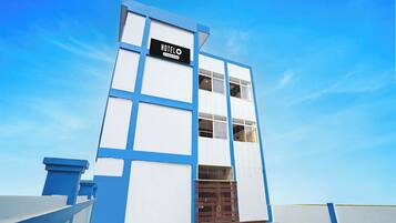 A modern hotel building with a sign reading 'HOTEL' and a company-serviced logo.