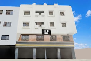 Un edificio de varios pisos con un letrero que dice 'HUELO', indicando un hotel.