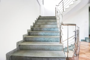 Una escalera con barandillas de metal y piso de madera.