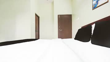 Una habitación de hotel con una cama, una puerta y una obra de arte colgada en la pared.