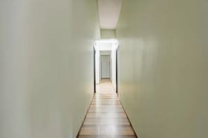 Un pasillo estrecho con una luz al final, que conduce a una puerta.