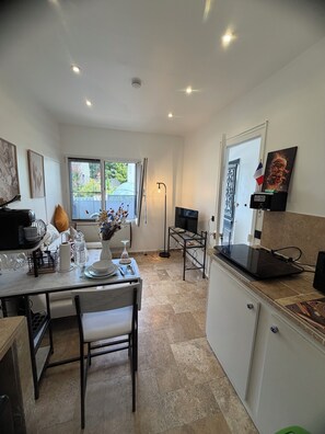 A modern kitchen with a dining area, a TV, and a flag. - Fabulous 4-bedroom townhome with AC in charming Rueil-Malmaison (Rueil-Malmaison)