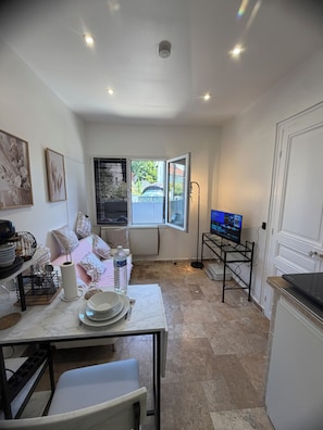 A compact kitchen with a dining area, a TV on a stand, and a window with blinds. - Fabulous 4-bedroom townhome with AC in charming Rueil-Malmaison (Rueil-Malmaison)