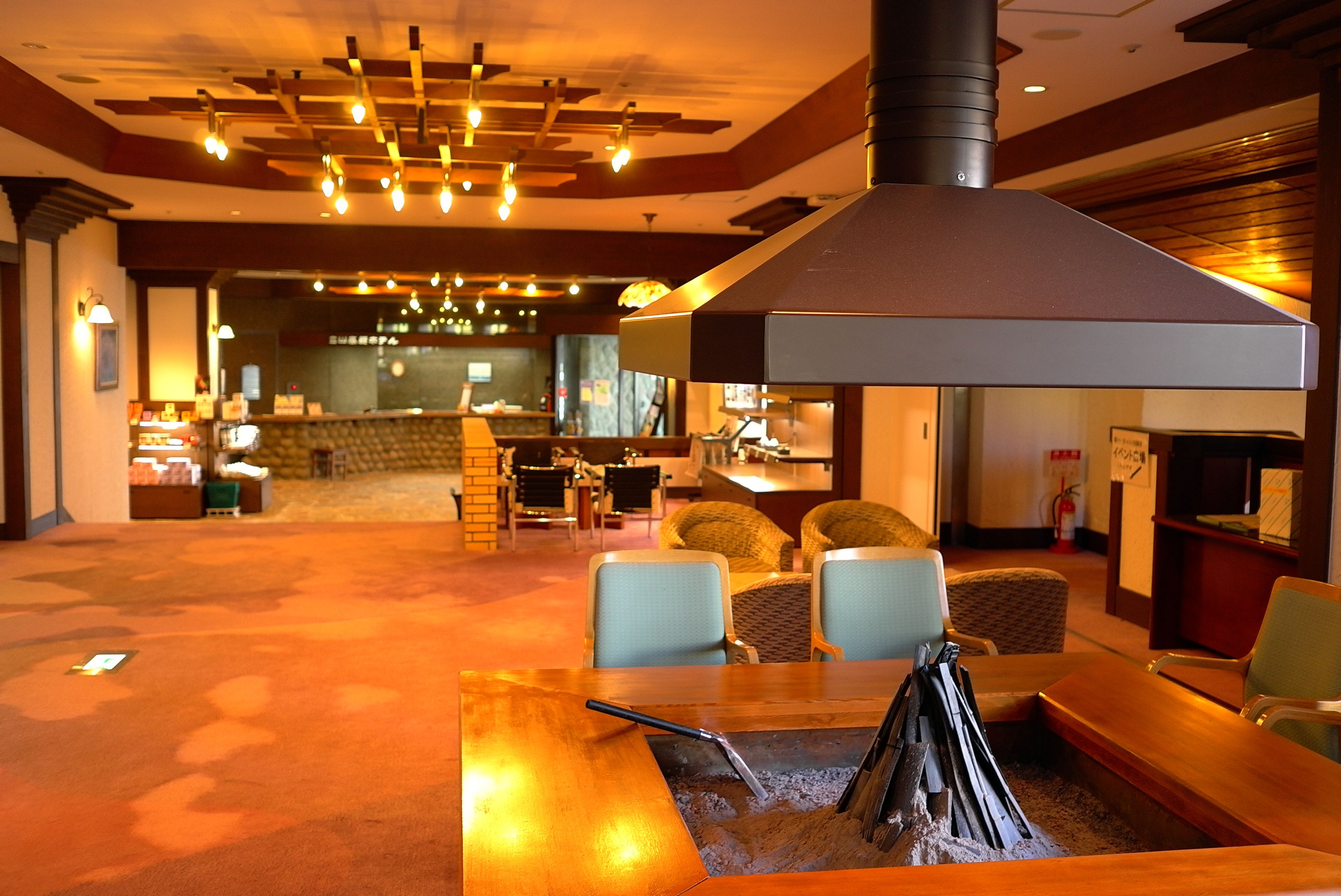 A hotel lobby with a bar area, seating, and a fireplace.