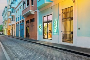 A street with buildings, one with a sign for 'Sugar Cane Gastro'. - Grand Galleria — Old San Juan Private Patio (San Juan)