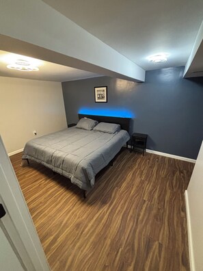Ein Schlafzimmer mit einem Bett, einem Nachttisch und einer Deckenleuchte.