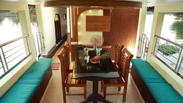 Un espace repas comprenant une table, des chaises et un ventilateur.