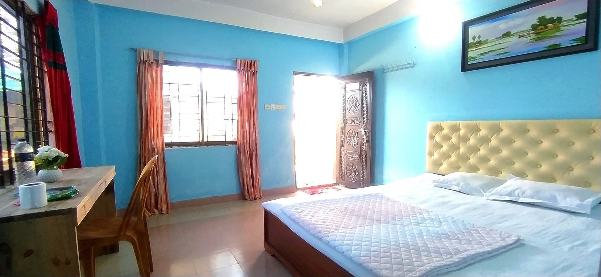Une chambre à coucher avec un lit, un bureau et une fenêtre avec des rideaux.