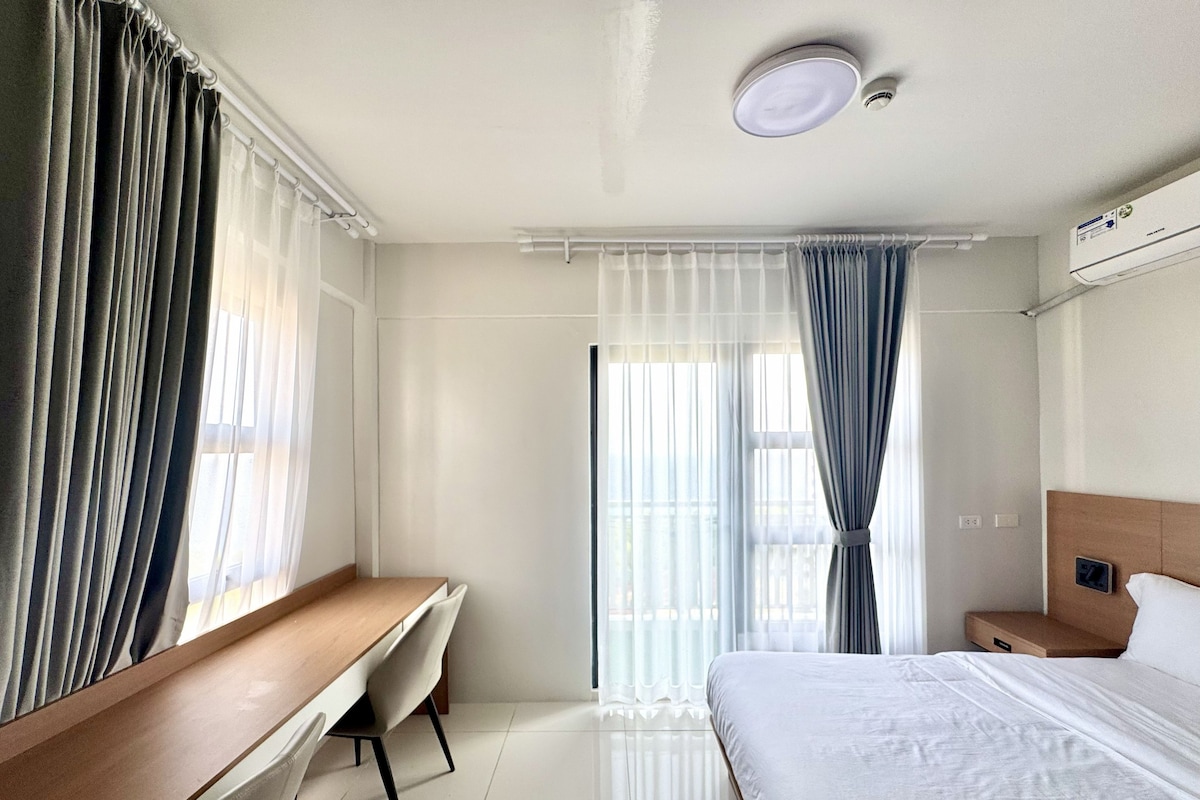 Una habitación de hotel con una cama, un escritorio y una silla.