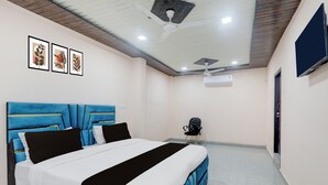 A bedroom with a bed, a chair, a TV, and an air conditioning unit. - Hotel O Shri Buddheshwar Temple Lucknow (Lucknow)