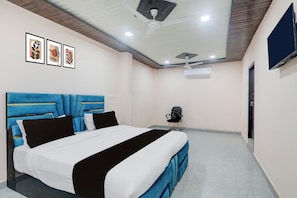 Une chambre à coucher comprenant un lit, une chaise, un téléviseur et un appareil de climatisation.
