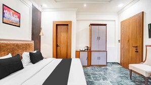 Ein Hotelzimmer mit einem Bett, einem Kleiderschrank, einem Schreibtisch und einem Stuhl.