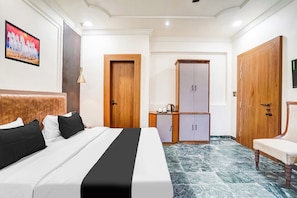 Una camera d'albergo con un letto, un armadio, una scrivania e una sedia.