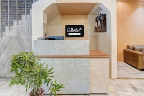 A reception desk with a sign indicating it's a company-serviced collection point. - OYO Collection O Ratan Lal Nagar (Kanpur)