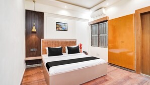 Ein Schlafzimmer mit Bett, Kleiderschrank, einem Gemälde und einem Fenster.