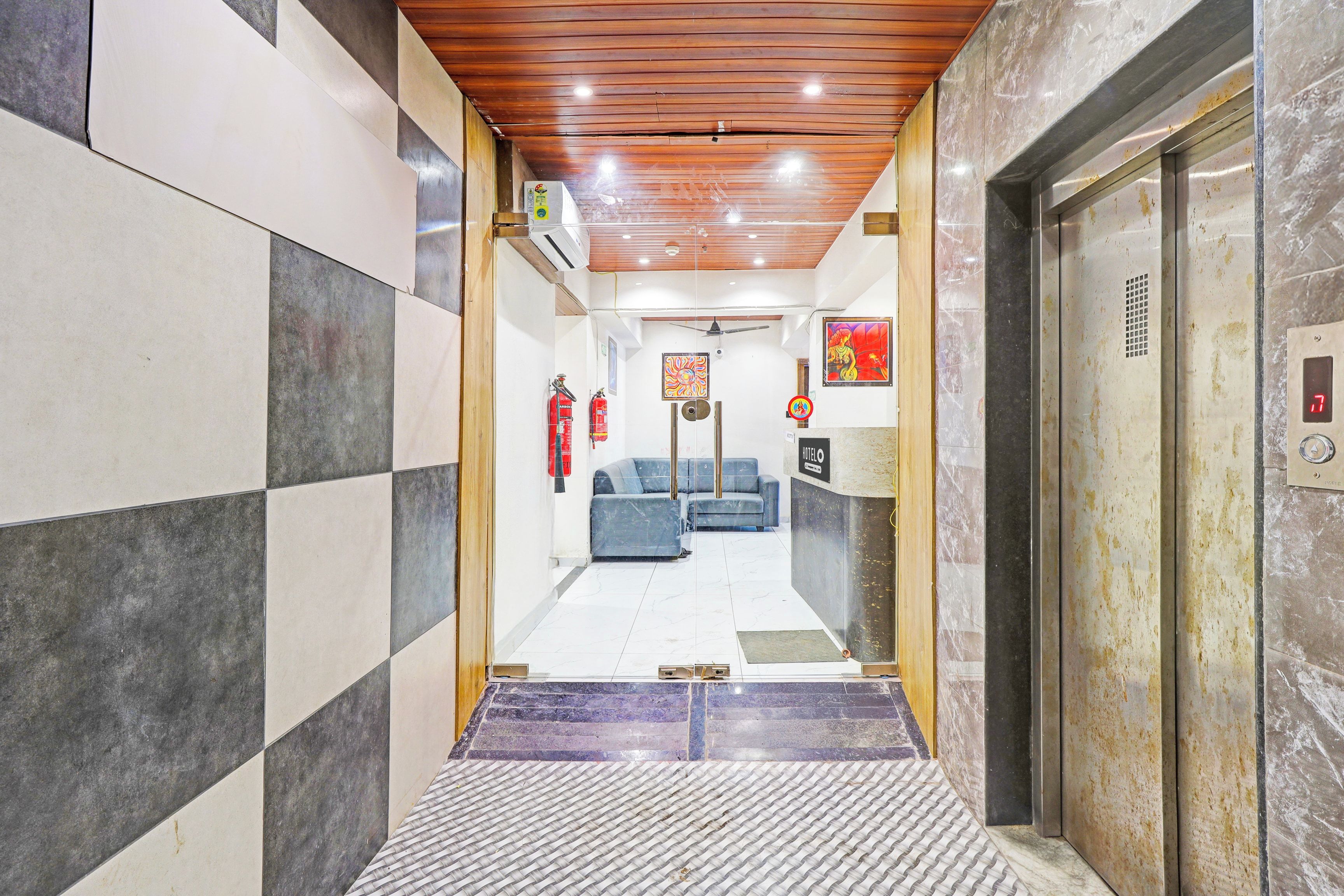 Un hall de hotel con mostrador de recepción, un escritorio de información y una zona de estar.
