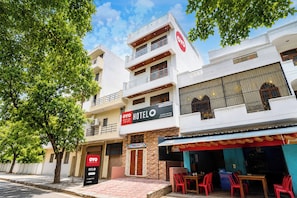 A hotel with a sign indicating it is a serviced company, a reception area, and a restaurant with outdoor seating.