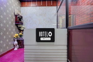 Un'area reception di un hotel con un cartello che indica il servizio OYO.