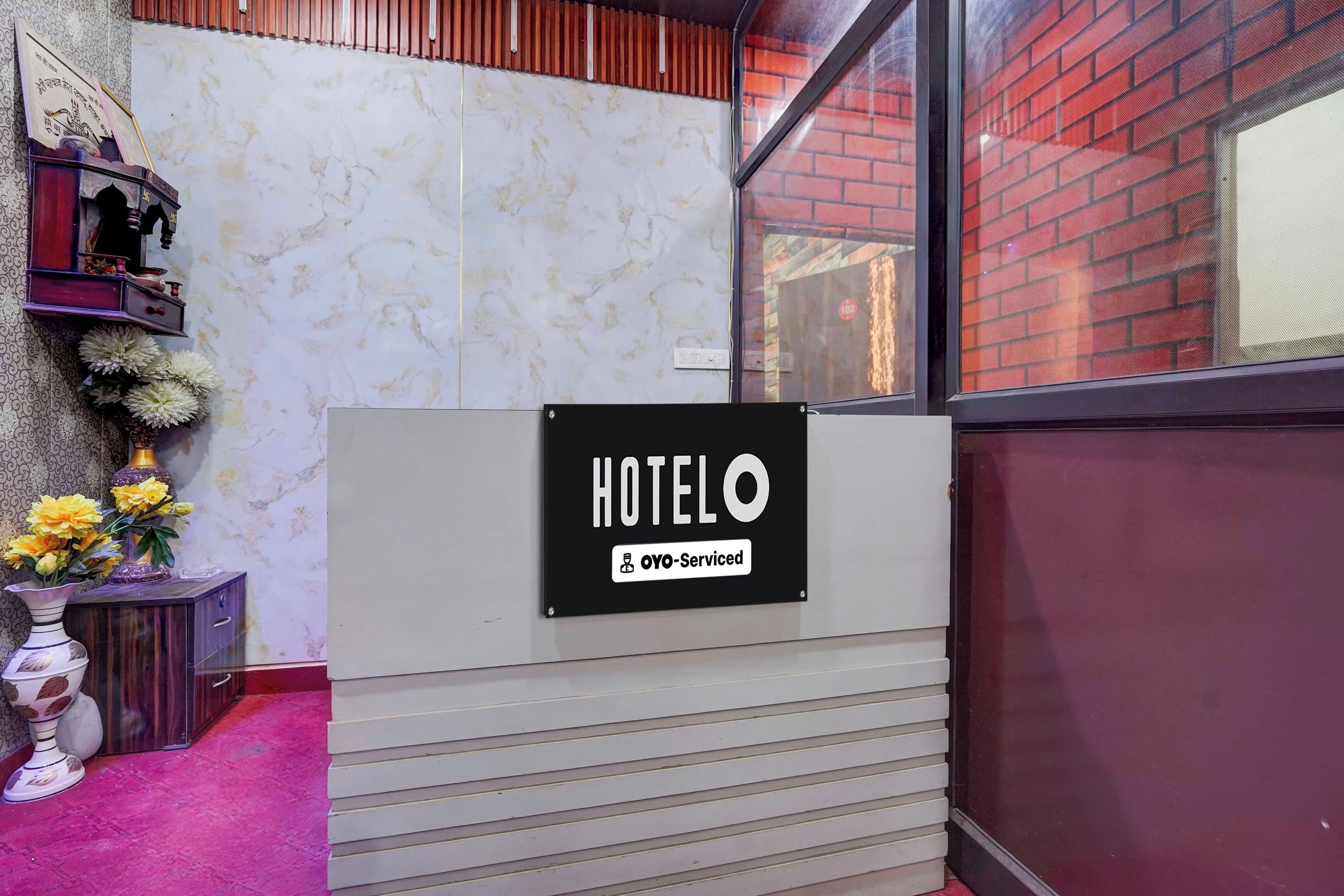 Una reception hotel con un cartello che indica il servizio offerto da OYO.
