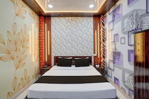 Una camera d'albergo con un letto grande, una testiera in legno, un comodino con una lampada e pannelli decorativi a parete.