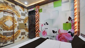 A hotel room with a bed, a wall with a leaf pattern, a door, and a window. - Hotel O Gurdev Metro Station Kanpur (Kanpur)