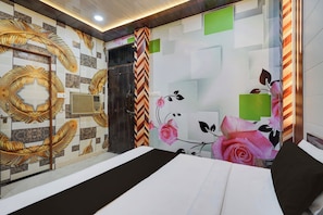 Una camera d'albergo con un letto, una parete decorata con un motivo a foglia, una porta e una finestra.