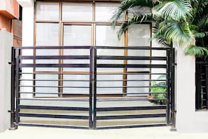 A gated entrance with a metal gate and a window with a grid pattern. - Super Hotel O Tagore Park Laskarhat (Kolkata)
