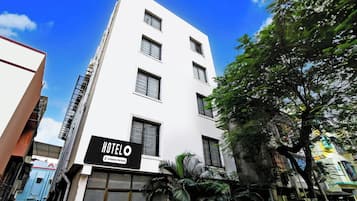 Un edificio de hotel con múltiples ventanas y un cartel que indica que es un establecimiento de servicio propio.