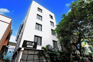 Un edificio de hotel con múltiples ventanas y un cartel que indica que es un establecimiento de servicio propio.