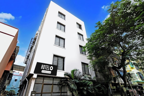 Un edificio de hotel con múltiples ventanas y un cartel que indica que es un establecimiento de servicio propio.