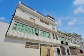 Um hotel de vários andares com fachada moderna, grandes janelas e um letreiro chamativo com a palavra 'HOTEL'.
