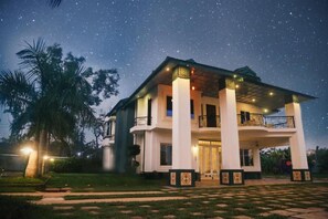A two-story building with a balcony, under a starry sky.