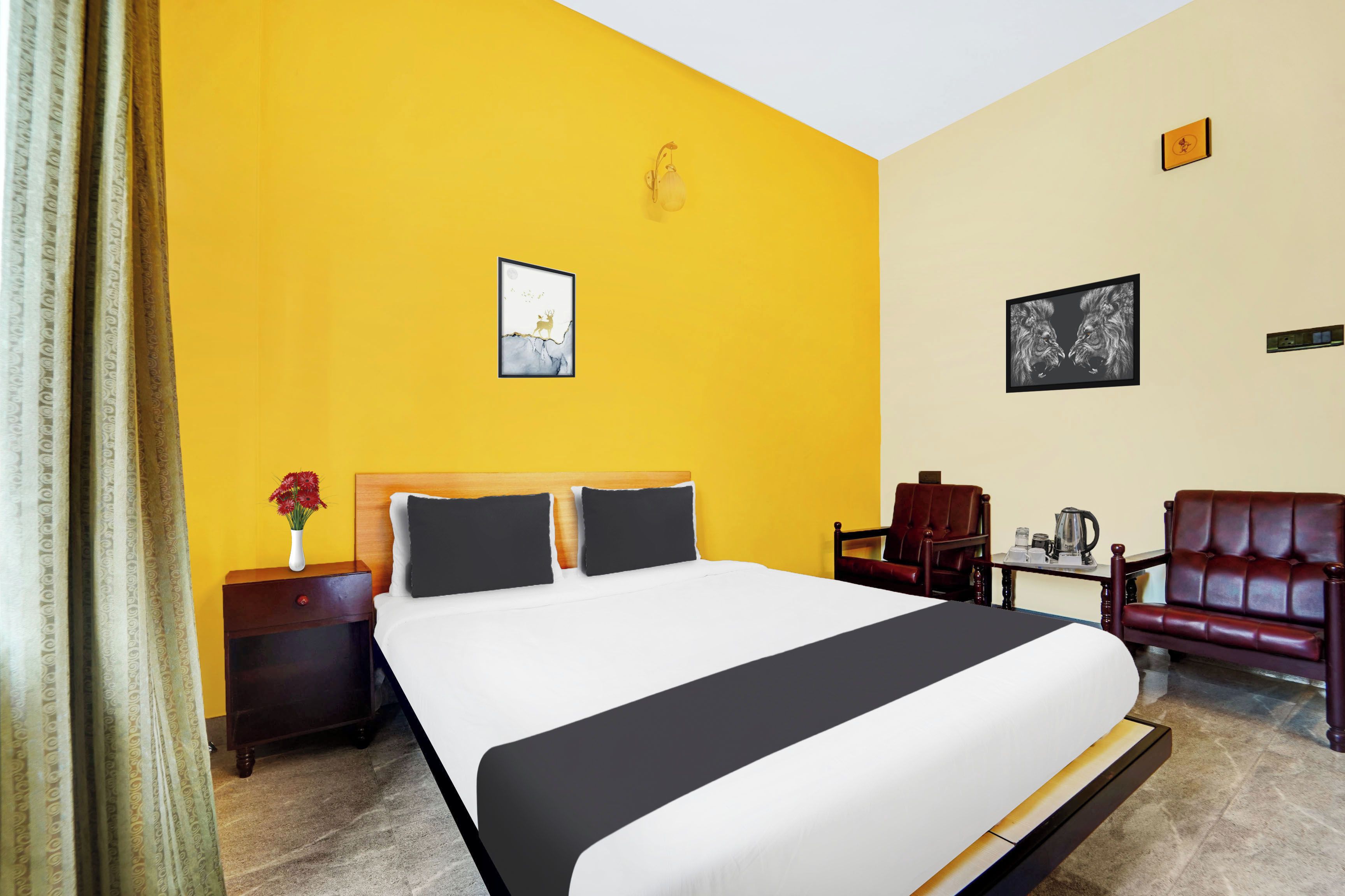Habitación de hotel con una cama grande, una mesita de noche, una silla y una pequeña mesa con una tetera.
