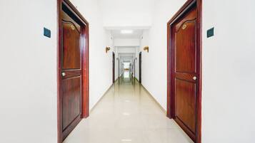 A long, narrow hallway with wooden doors on either side and a tiled floor.