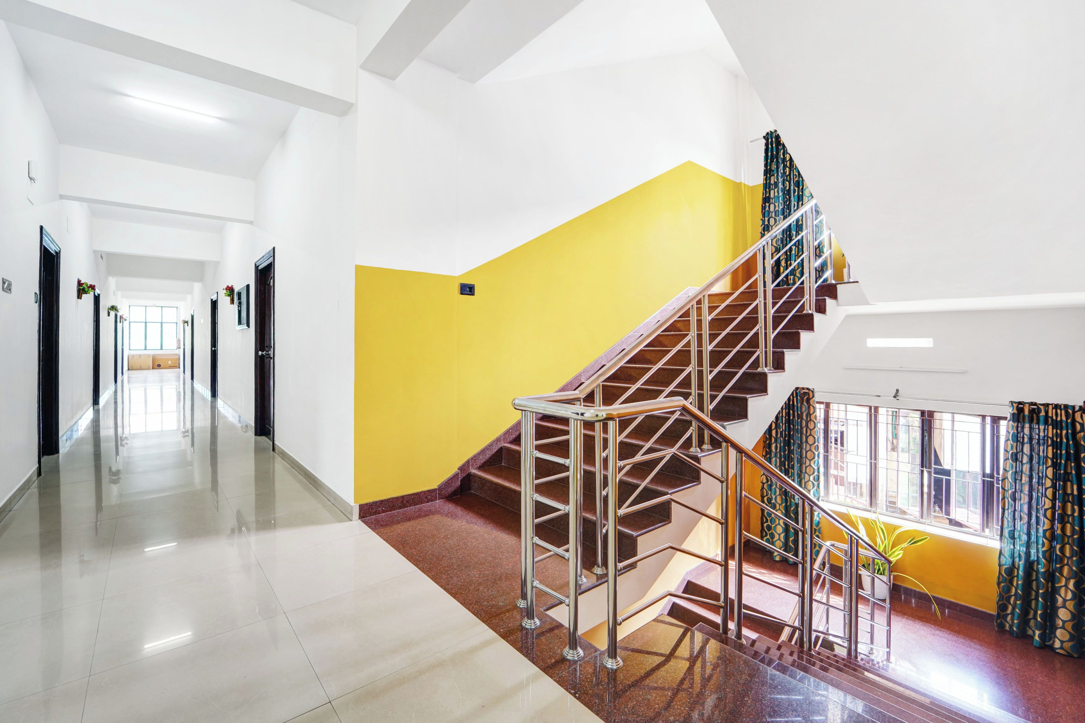 Ein Hotelkorridor mit einer Treppe, die zu einem Balkon führt.