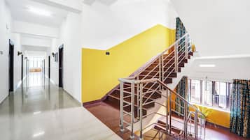 Ein Hotelkorridor mit einer Treppe, die zu einem Balkon führt.