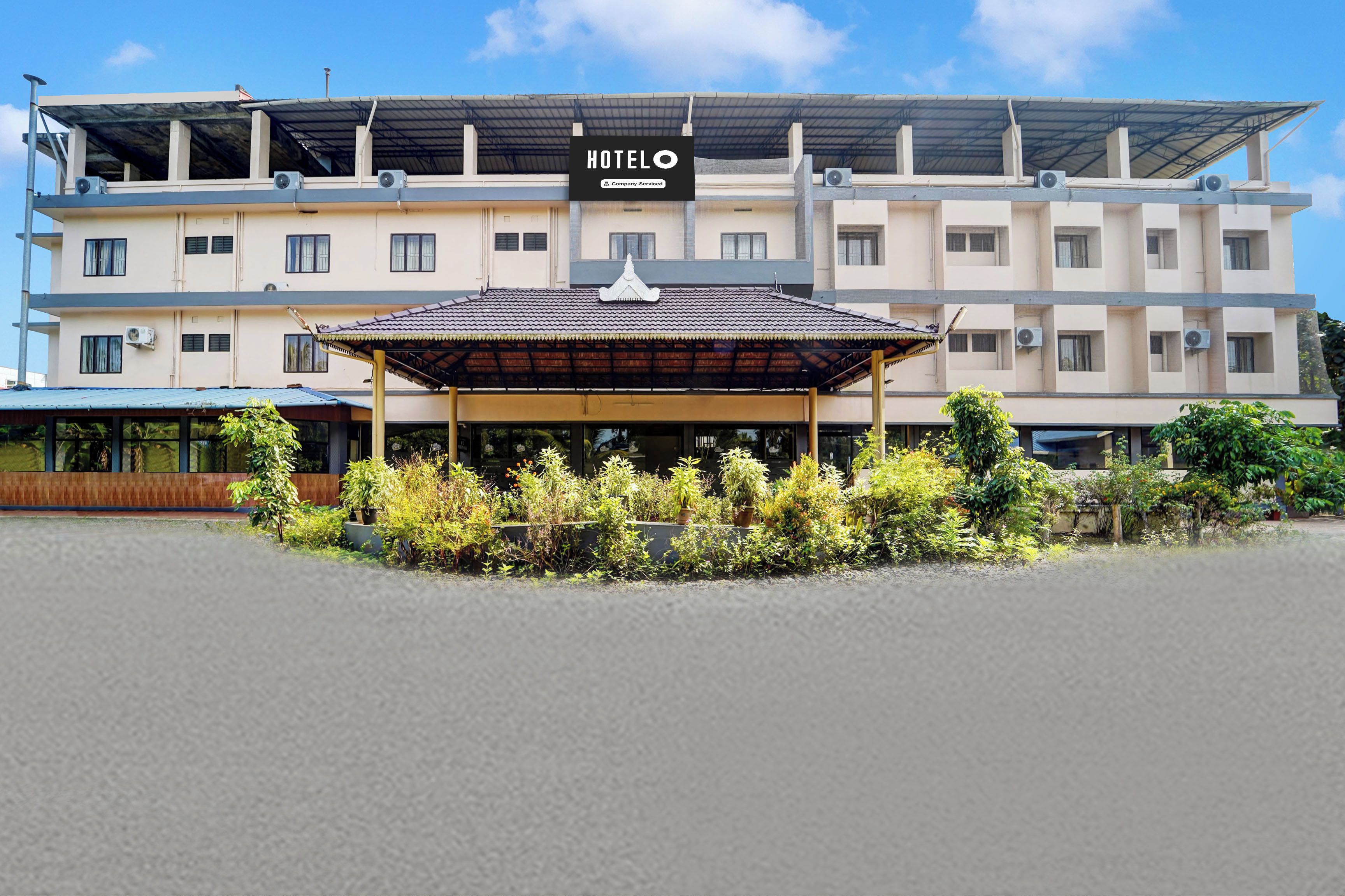 Hotel com entrada coberta, vários andares e aparelhos de ar condicionado.
