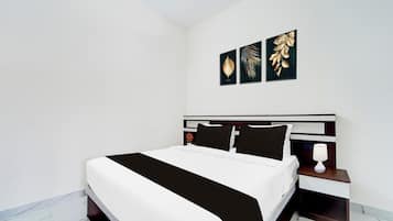 Un dormitorio moderno con una cama grande, una mesita de noche y tres obras de arte colgadas en la pared.